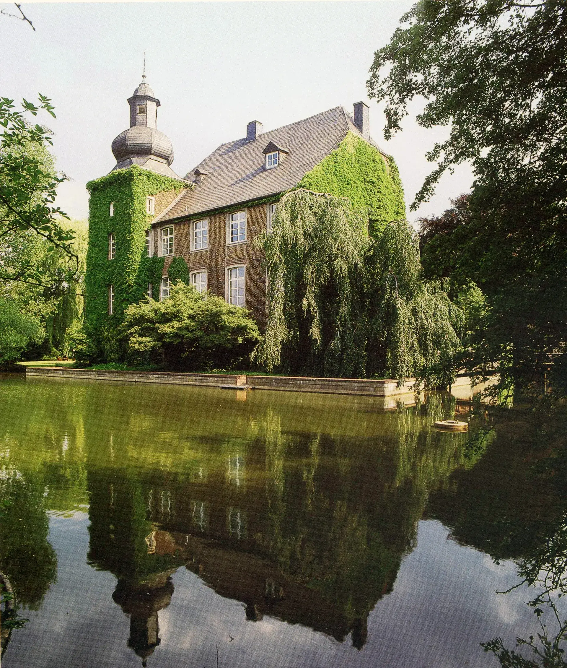 Haus Wohnung in Voerde-Möllen Historisches Haus Wohnung in Voerde-Möllen mit Wassergraben, bewachsener Fassade und Spiegelung im Wasser